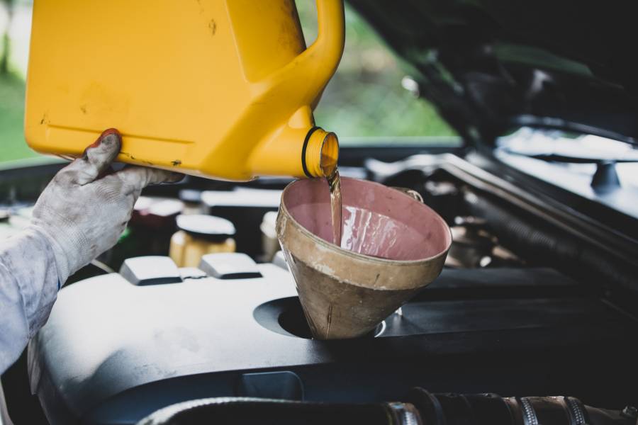 Mecânico trocando óleo da direção hidráulica de carro