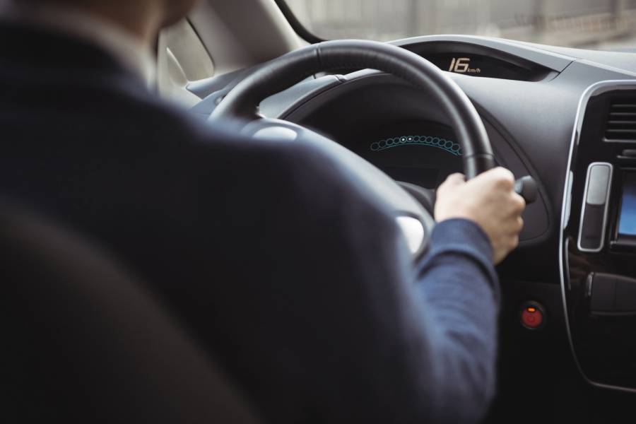 Motorista conduzindo carro com direção elétrica