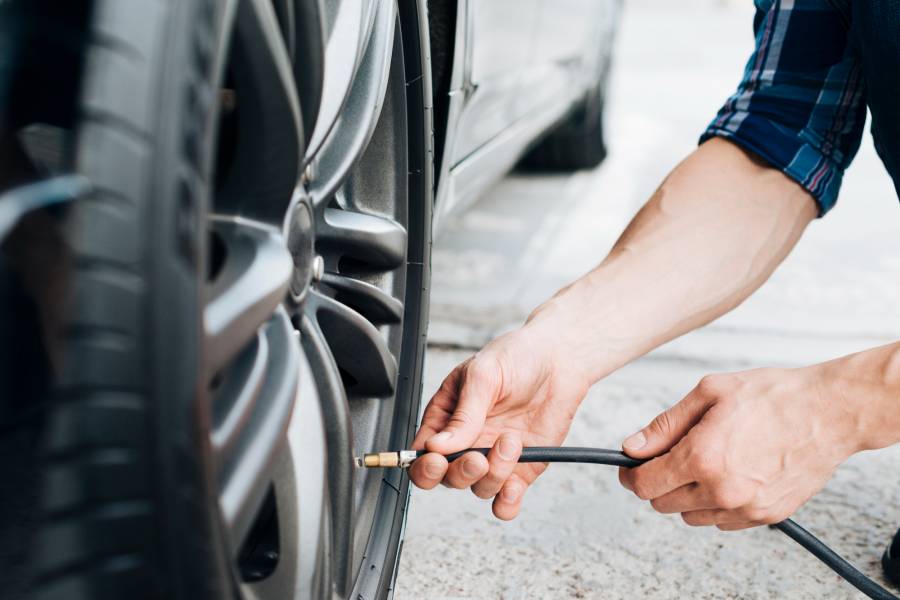 Motorista realizando calibragem de pneu